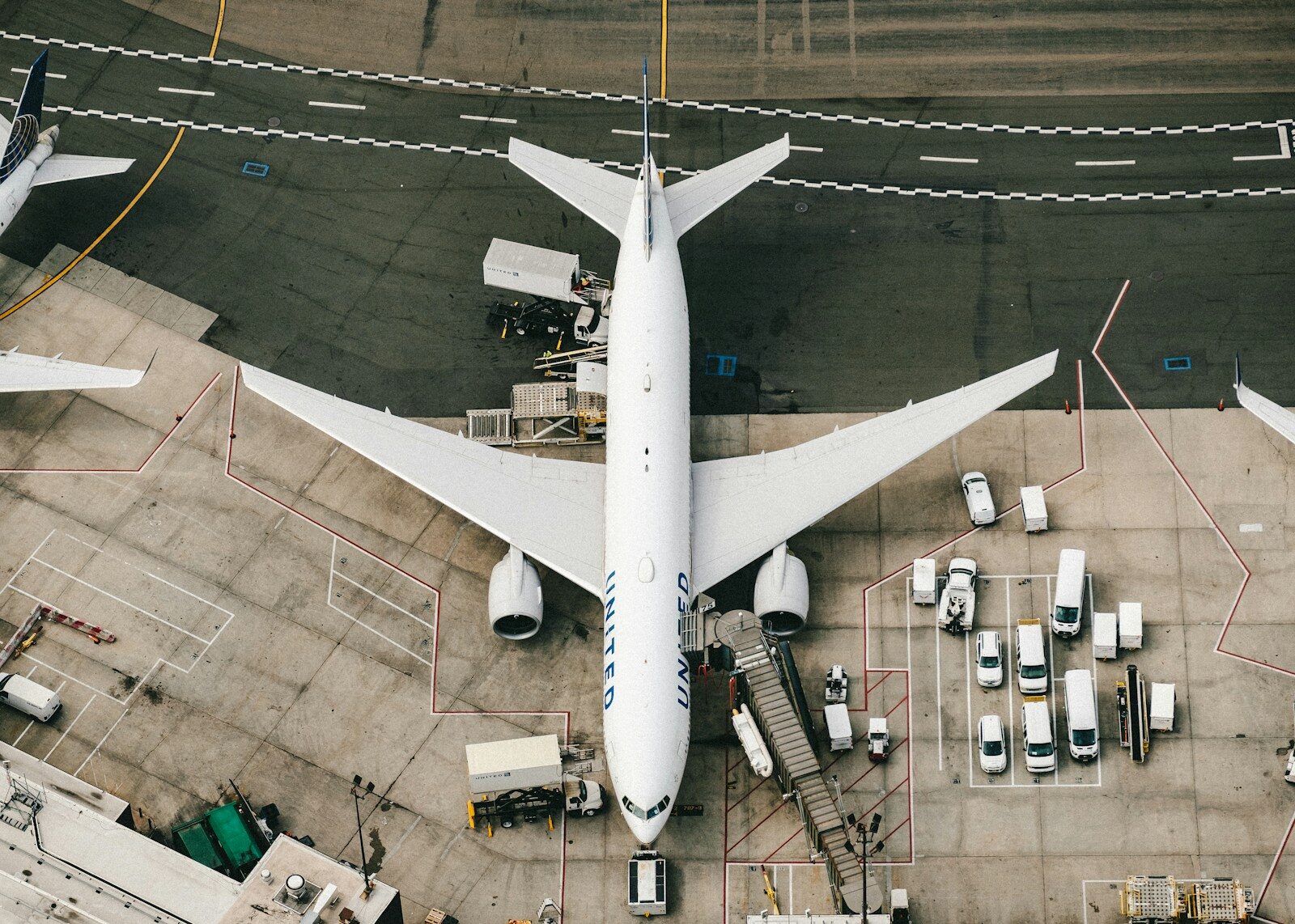 Photo by Chris Leipelt white and blue airplane on airport during daytime