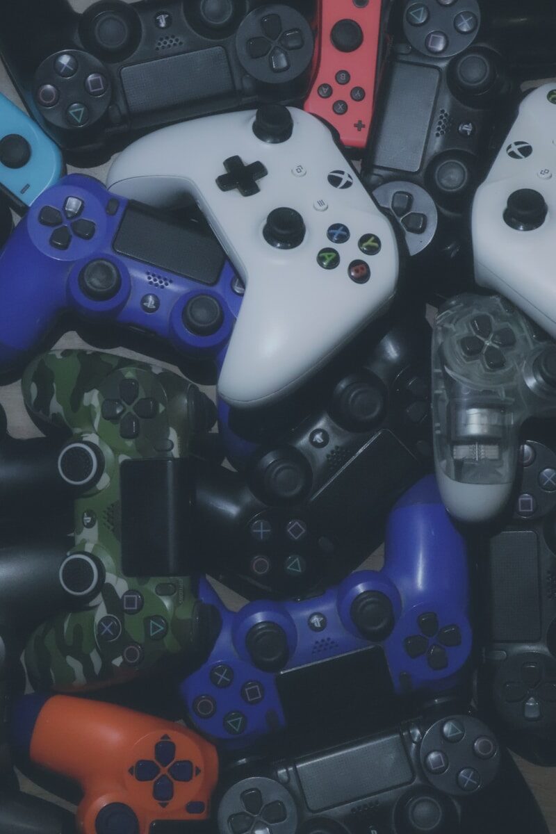 Photo by Pragii assorted-colored Xbox and Sony Playstaion game controller lot