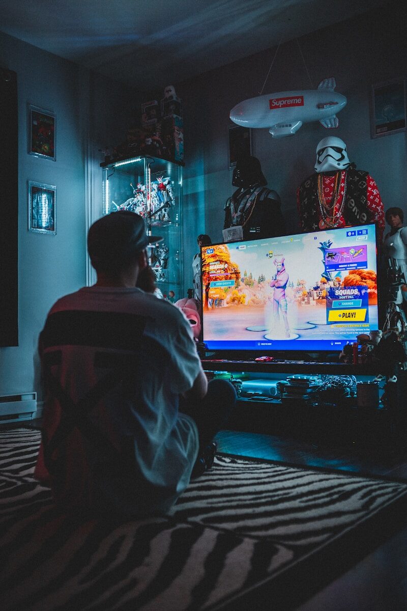 Photo by Erik Mclean man in red shirt watching tv